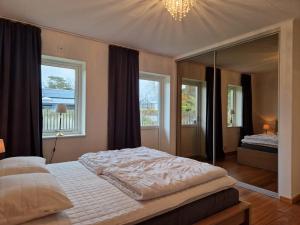 1 dormitorio con 1 cama grande y espejo grande en Mellby Kite Surf Villa, en Mellbystrand
