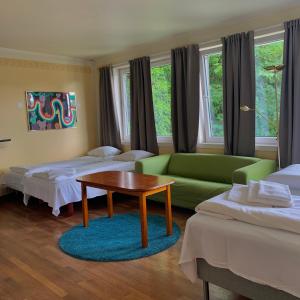 曼達爾的住宿－SKAP Hostel Mandal，客房设有两张床、一张沙发和一张桌子。