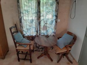einen Esstisch, 2 Stühle und eine Lampe in der Unterkunft Les loges de yoff in Ambon