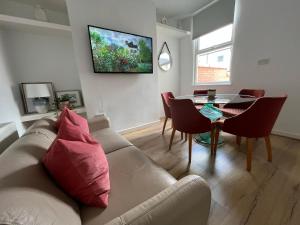 a living room with a couch and a table at 2025 Award Winner Liverpool Peach House - 4 Bedrooms in Liverpool