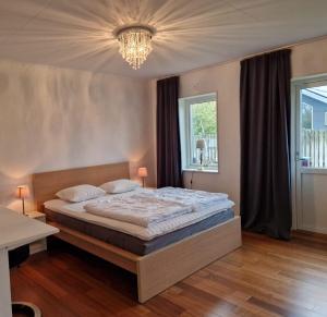 a bedroom with a large bed and a chandelier at Mellby Kite Surf Villa in Mellbystrand