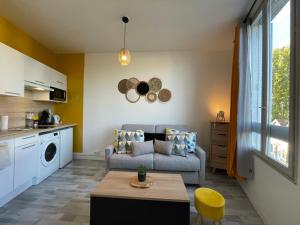 a living room with a couch and a table at Studio proche de la gare in Auxerre