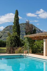 a swimming pool with a pergola and mountains in the background at Buccara Casa Gran Daniel I in Pollença