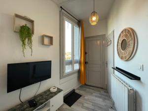 a living room with a flat screen tv and a window at Studio proche de la gare in Auxerre