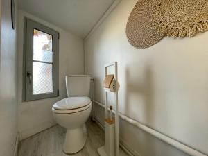 a bathroom with a toilet and a window at Studio proche de la gare in Auxerre