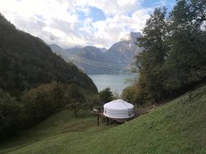 a large tent on a hill next to a lake at Panorama Jurte über dem Uri-See B in Sisikon