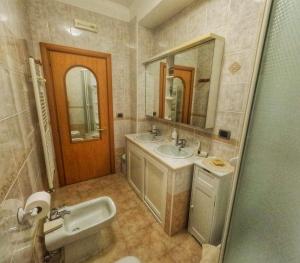La salle de bains est pourvue de 2 lavabos et d'un miroir. dans l'établissement Aurora B&B, à Matera