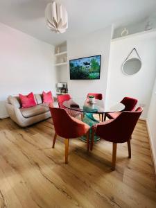 uma sala de estar com uma mesa de vidro e cadeiras em Liverpool Peach House - 4 bedrooms em Liverpool