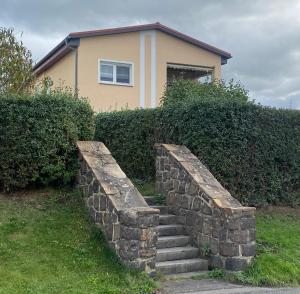 a stone retaining wall in front of a house at Ferienwohnung „Thea“ in Bad Lausick