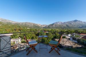 two chairs on a balcony with mountains in the background at Vasilikata in Agios Konstantinos