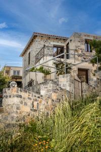 a stone house with a staircase in front of it at Vasilikata in Agios Konstantinos