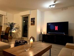 ein Wohnzimmer mit einem TV und einem Holztisch in der Unterkunft Stylish, cosy flat close to Cologne City Center in Köln