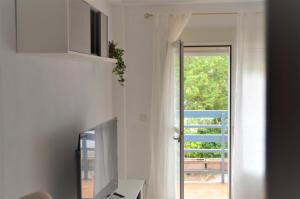 uma sala de estar com uma televisão e uma porta de vidro deslizante em La posada Cordobesa em Córdoba