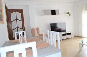 uma sala de estar com uma mesa e cadeiras e uma televisão em La posada Cordobesa em Córdoba