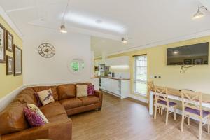 a living room with a couch and a dining room at Squirrel Lodge 43 with Hot Tub in Newton Stewart