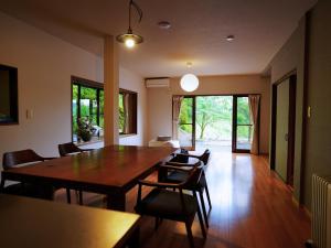 a dining room with a wooden table and chairs at GUEST HOUSE Ichinoyado - Vacation STAY 39544v in Tajimi