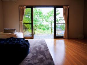 Cette chambre comprend un lit et une grande porte en verre. dans l'établissement GUEST HOUSE Ichinoyado - Vacation STAY 39544v, à Tajimi