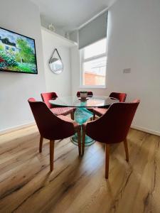 a dining room with a glass table and chairs at Liverpool Peach House - 4 bedrooms in Liverpool