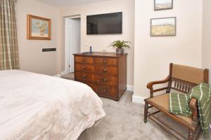 a bedroom with a bed and a dresser with a television at The Masons Arms in Newcastle under Lyme