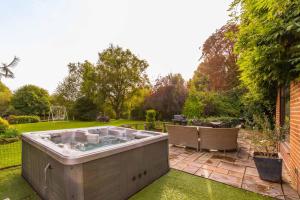 a hot tub in the middle of a garden at Four Seasons in Norwich