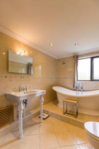 a bathroom with a sink and a tub and a toilet at Four Seasons in Norwich