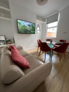 a living room with a couch and a table at Liverpool Peach House - 4 bedrooms in Liverpool