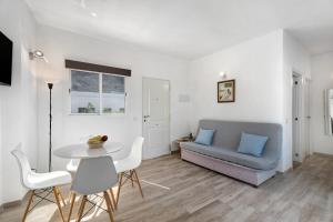 sala de estar con sofá, mesa y sillas en Vivienda vacacional La Era ll en Vallehermoso