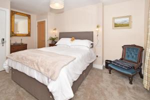 a bedroom with a large bed and a blue chair at The Masons Arms in Newcastle under Lyme