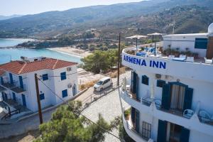 a white building with a sign that reads karma inn at ARMENA INN in Armenistis