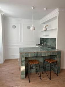 a kitchen with a counter and two stools at Petit cocon cosy in Bordeaux