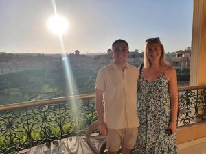 a man and a woman standing on a balcony at Grand Museum Pyramids Inn in Giza