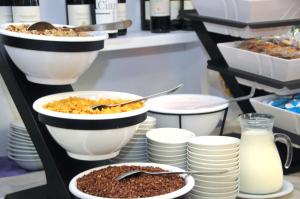un buffet con tazones de comida, platos y leche en Hotel Oliver, en Caorle