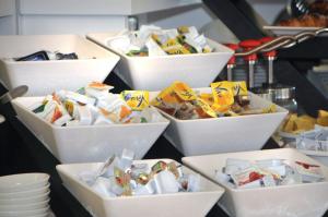 Hotel Oliver في كاورلي: مجموعة من الأطباق مليئة بالطعام على منضدة