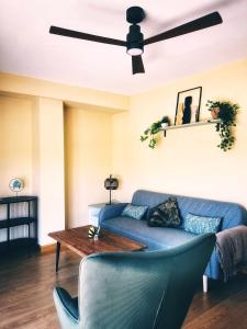 Una sala de estar con un sofá azul y una mesa. en Almamater salamanca, en Salamanca