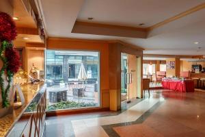 una hall di un ristorante con tavolo e finestra di Eastiny Bella Vista Hotel a Centro di Pattaya