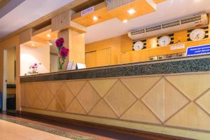 a lobby with a counter with clocks on the wall at Eastiny Bella Vista Hotel in Pattaya Central