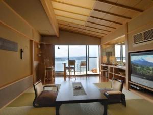 Naniwa Issui في ماتسو: غرفة معيشة مع طاولة وتلفزيون بشاشة كبيرة