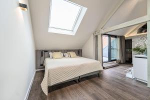 een slaapkamer met een bed en een raam bij Hof van In & Wellness in Hasselt