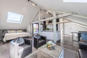 a living room with a bed and a couch and a table at Hof van In Boutique B&B en Privé Wellness in Hasselt
