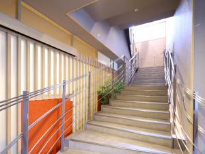 klatka schodowa w budynku z poręczą schodową w obiekcie Dormy Inn Tokyo Hatchobori Hot Spring w Tokio
