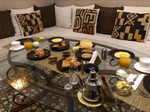 - une table basse avec de la nourriture sur le canapé dans l'établissement Riad Home Zemrane, à Marrakech