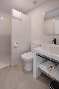 a white bathroom with a toilet and a sink at Tres Tocs in Ciutadella +23 photos