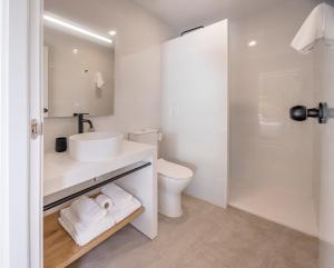 a white bathroom with a sink and a toilet at Tres Tocs in Ciutadella
