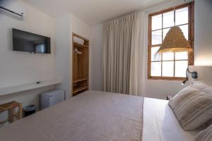 um quarto com uma grande cama branca e uma janela em Tres Tocs em Ciutadella