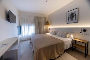 una camera d'albergo con letto e scrivania di Tres Tocs a Ciutadella