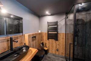 y baño con lavabo negro y ducha. en Domandi mountain holiday lodges en Przesieka