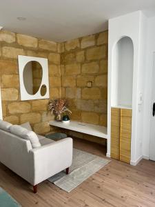 een woonkamer met een bank en een stenen muur bij Petit cocon cosy in Bordeaux