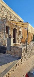 - un bâtiment en pierre avec une tente sur le côté dans l'établissement Panos Renos Studio, a cozy home by the beach!, à Kalymnos