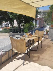 une table et des chaises sous un parapluie jaune dans l'établissement Panos Renos Studio, a cozy home by the beach!, à Kalymnos