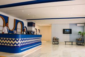 een lobby van een ziekenhuis met twee mensen aan een balie bij Marina Cap Monastir- Appart'Hôtel in Monastir